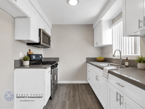 Gardena apartment for rent - A kitchen with white cabinets and a black stove top.