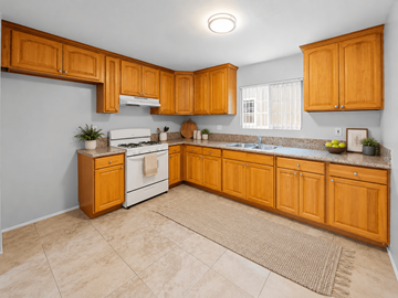 Long Beach apartment for rent - A kitchen with wooden cabinets and a white stove top oven.
