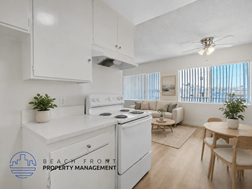 Inglewood apartment for rent - A kitchen with white appliances and a dining table with chairs.