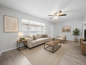 Long Beach apartment for rent - A living room with a beige couch, a coffee table, and a ceiling fan.