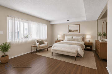 Lennox apartment for rent - A well-lit bedroom with a large bed and a chair.
