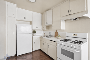 Lennox apartment for rent - A white kitchen with a refrigerator, oven, and sink.