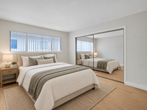 Downey apartment for rent - A bedroom with a large bed and a mirror.