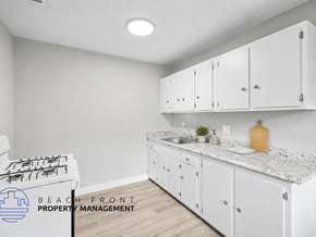 Anaheim apartment for rent - A kitchen with white cabinets and a marble countertop.