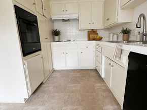 Torrance apartment for rent - A kitchen with white cabinets and a black fridge.