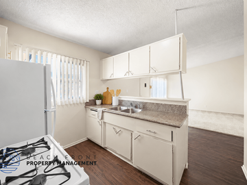Gardena apartment for rent - A kitchen with white cabinets and a countertop with a sink.
