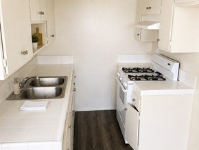 Wilmington apartment for rent - A white kitchen with a stove, sink, and cabinets.