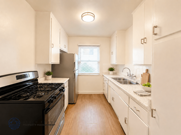 Redondo Beach apartment for rent - A kitchen with a black stove top oven and white cabinets.