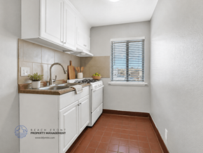 Carson apartment for rent - A kitchen with white cabinets and a brown tile floor.