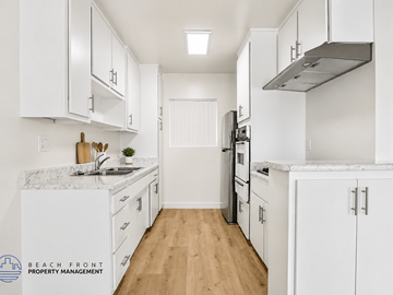 Gardena apartment for rent - A kitchen with white cabinets and a marble countertop.