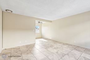 Hawthorne apartment for rent - A spacious room with tiled flooring and a ceiling fan.