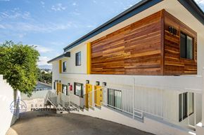 Los Angeles apartment for rent - a building with a wooden facade and a white building with yellow doors