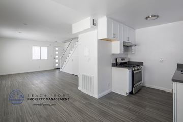 Los Angeles apartment for rent - a renovated kitchen with white cabinets and a stove and a staircase