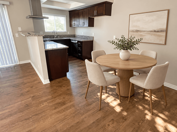 Westminster apartment for rent - A kitchen with a table and chairs in the foreground and a painting on the wall.