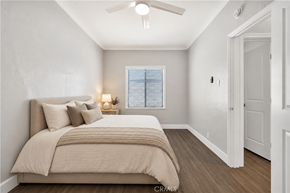 Long Beach apartment for rent - A bedroom with a bed, pillows, a blanket, a ceiling fan, and a window with blinds.