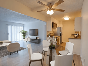 Downey apartment for rent - A living room with a television, a dining table and chairs, and a kitchen area.