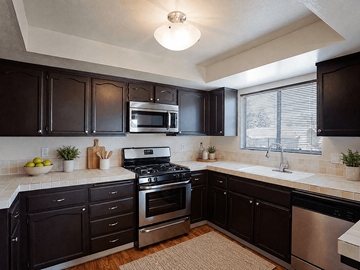 La Habra apartment for rent - A kitchen with black cabinets and stainless steel appliances.
