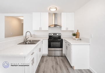 Orange apartment for rent - A kitchen with white cabinets and a stainless steel oven.