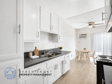 Inglewood apartment for rent - A kitchen with white cabinets and a black stove top oven.