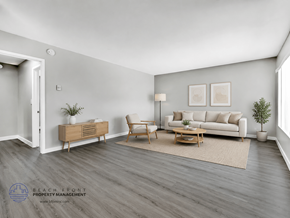 Inglewood apartment for rent - A living room with a white couch, a wooden cabinet, a chair, a table, and a rug.