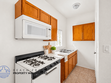 Long Beach apartment for rent - A kitchen with a black stove top oven and a white microwave above it.