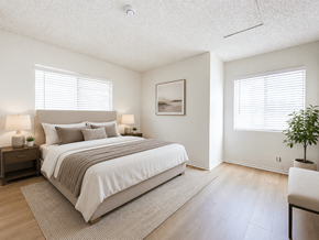 Pomona apartment for rent - A bedroom with a large bed and a painting on the wall.