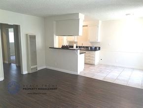 Inglewood apartment for rent - an empty kitchen with white cabinets and a wooden floor