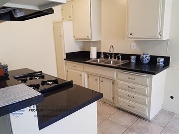 Inglewood apartment for rent - a kitchen with black counter tops and white cabinets
