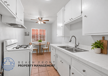 Long Beach apartment for rent - A kitchen with white cabinets and a tiled floor.
