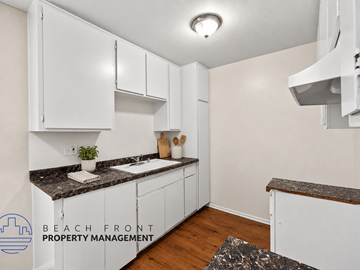 Long Beach apartment for rent - A kitchen with white cabinets and a granite countertop.