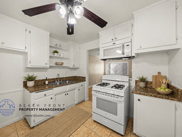Downey apartment for rent - A kitchen with white cabinets and a stove top oven.