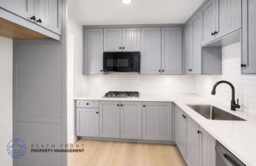 Los Angeles apartment for rent - A kitchen with grey cabinets and a white countertop.