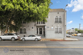Los Angeles apartment for rent - A street view of a building with cars parked in front.