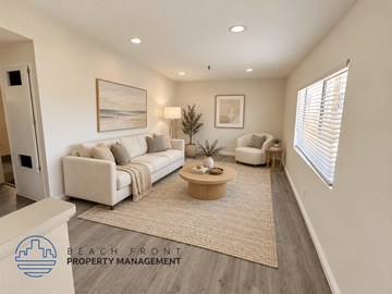 Santa Ana apartment for rent - A well-lit living room with a white sofa, a coffee table, and a painting on the wall.