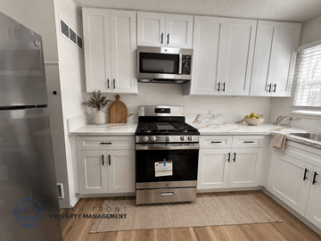 Santa Ana apartment for rent - A kitchen with white cabinets and a stainless steel refrigerator.