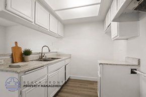Torrance apartment for rent - A kitchen with white cabinets and a marble countertop.