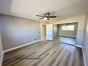 Redondo Beach apartment for rent - an empty living room with a ceiling fan and a glass door