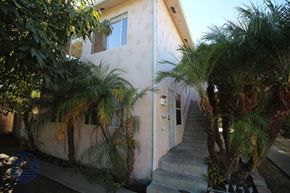 San Pedro apartment for rent - A house with a staircase and trees in front.
