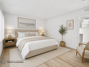 Los Angeles apartment for rent - A bedroom with a large bed, a small plant, and a chair.