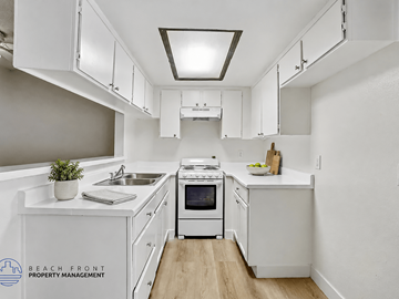 Los Angeles apartment for rent - A kitchen with white cabinets and a stove top oven.