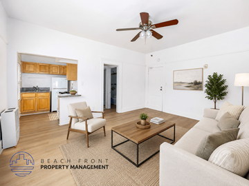 Los Angeles apartment for rent - A living room with a couch, chair, and coffee table with a logo for Beach Front Property Management.