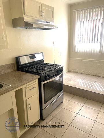 Redondo Beach triplex for rent - A kitchen with a black stove top oven and a white tile floor.