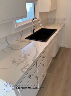 Redondo Beach apartment for rent - A kitchen with a marble countertop and a black cutting board.