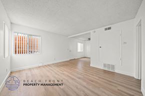 Manhattan Beach apartment for rent - A spacious room with wooden flooring and white walls, with a window covered by orange blinds.