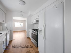 San Pedro apartment for rent - A kitchen with white appliances and wooden floors.