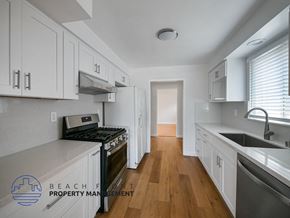 San Pedro apartment for rent - A kitchen with white cabinets and a stove top oven.