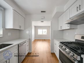 San Pedro apartment for rent - A kitchen with white cabinets and a stove top oven.
