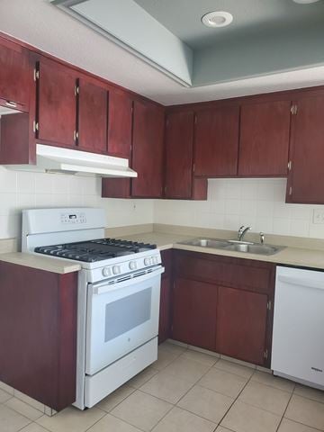 Huntington Beach apartment for rent - A kitchen with a white stove and brown cabinets.