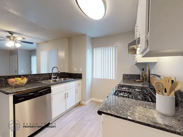 Paramount apartment for rent - A kitchen with a black stove top oven and white cabinets.