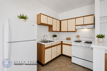 Los Angeles apartment for rent - A kitchen with wooden cabinets and a white stove top oven.